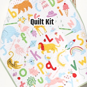 May include: A white quilt kit with a colourful alphabet design featuring animals and other objects. The kit includes fabric for the quilt top, backing, and binding. The quilt is designed by Kristin Blandford Designs.