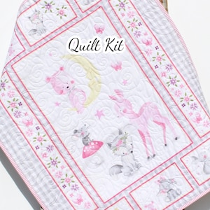 May include: A white and pink baby quilt kit with a whimsical design. The quilt features illustrations of animals, flowers, and butterflies. The text "Quilt Kit" is displayed on the quilt. The quilt is bordered with a pink and white gingham pattern.