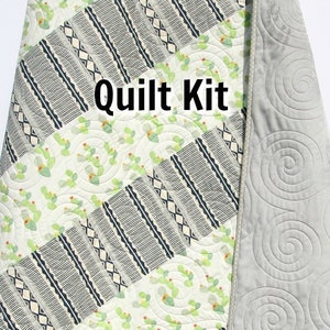 May include: A quilt kit featuring a cactus print fabric with a geometric pattern. The kit includes fabric for the quilt top, backing, and binding. The text "Quilt Kit" is visible in the image. The text "Kristin Blandford Designs" is also visible in the image.