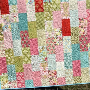 Modern baby quilt and throw quilt sewing pattern designed for 10 inch precut squares and layer cake fabric bundles with easy beginner quilt construction