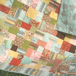 Layer cake quilt pattern instant download featuring a cozy throw quilt made with Bonnie and Camille floral fabrics and colorful 10 inch fabric squares