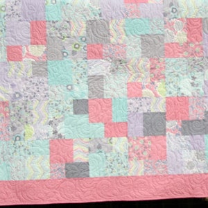 Modern Vintage quilt pattern featuring soft aqua, coral, cream, and floral fabrics arranged in a scrappy patchwork quilt design
