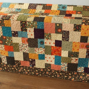 Throw quilt pattern PDF with modern patchwork blocks and floral fabric borders designed for beginner and confident beginner quilters