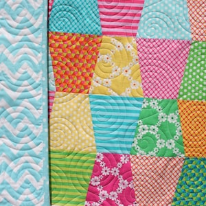 Bright and cheerful Tumbled quilt pattern made with colorful charm square fabrics in pink, turquoise, orange, lime, yellow, and purple tones. This easy PDF quilt pattern by Kristin Blandford Designs is perfect for beginner quilters looking for a fun baby quilt pattern, modern lap quilt design, or fast sewing project using 5 inch precuts.
