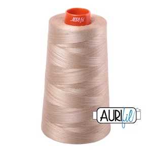 May include: A spool of beige Aurifil thread with the Aurifil logo on the side.