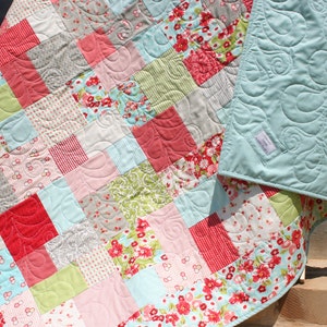 Instant download quilt pattern PDF featuring a modern vintage quilt layout with floral borders, pastel fabrics, and cozy handmade quilt styling