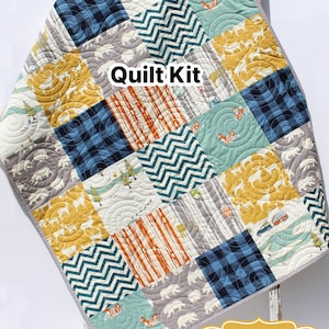 May include: Quilt kit with a variety of fabric squares in blue, yellow, gray, and orange. The fabric squares feature patterns such as circles, stripes, and zigzags. The quilt kit is labeled "Quilt Kit" and "Kristin Blandford Designs".