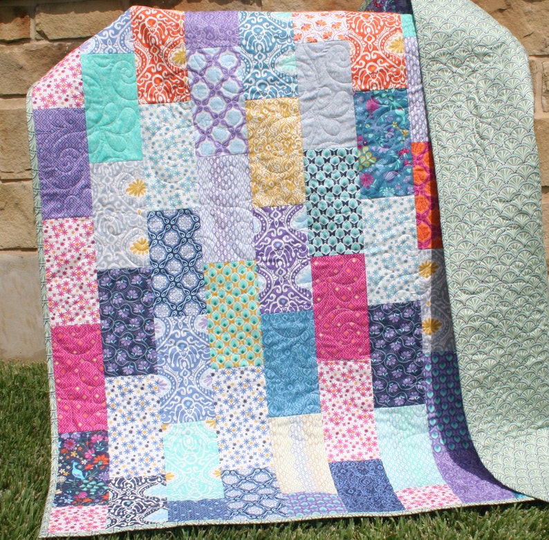 Modern patchwork quilt pattern PDF featuring bold geometric quilt blocks and colorful fabric placement perfect for beginner quilting projects