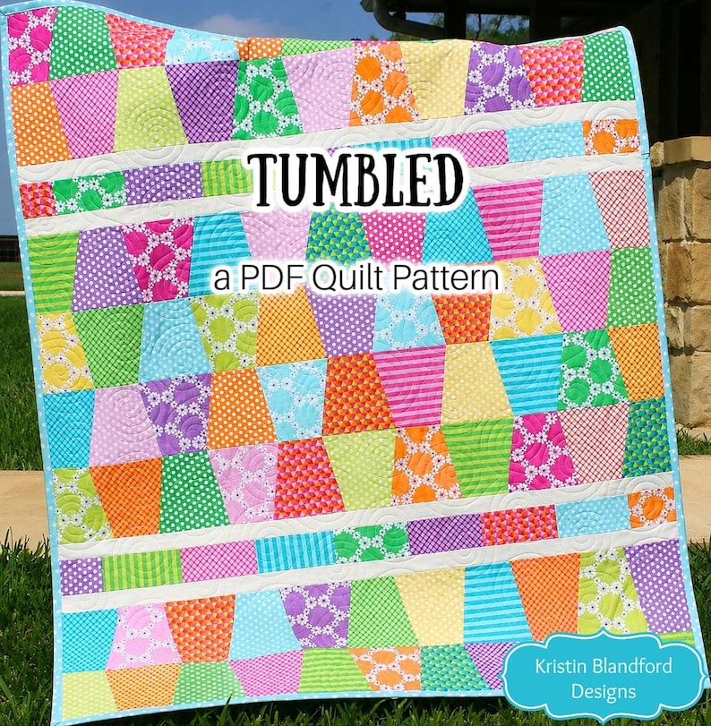 Downloadable Tumbled quilt pattern by Kristin Blandford Designs showcasing a colorful modern tumbling block quilt layout with bright patchwork fabrics and clean white sashing. This beginner friendly PDF quilt pattern includes baby and lap throw sizes and is perfect for charm packs, precut quilting fabric collections, and stash busting sewing projects.