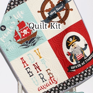 May include: A quilt kit with a nautical theme. The kit features a red, white, and blue ship, a pirate captain, a steering wheel, and the text "A pirate's life for me" and "Adventure awaits".