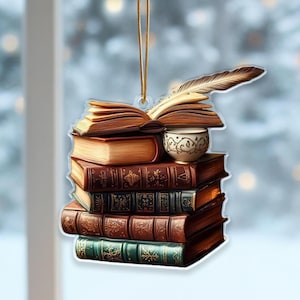 Peut inclure: Ornement représentant une pile de livres, une plume et une tasse à thé. Les livres sont dans des tons de marron et de vert. L'ornement est suspendu par une ficelle dorée, pour les amateurs de lecture.