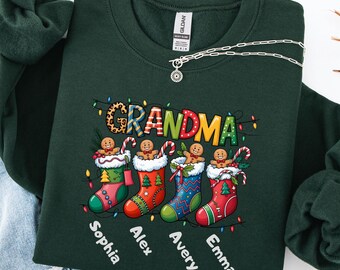 May include: Forest green sweatshirt with the word "GRANDMA" in a leopard print font. The sweatshirt features four Christmas stockings with gingerbread men and the names Sophia, Alex, Avery, and Emma.