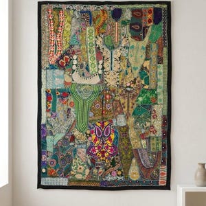 May include: A vibrant patchwork wall hanging with a black border. The textile is composed of various patterns and colours, including greens, blues, reds, and yellows. The design is intricate and detailed, creating a visually striking piece of art for the home.