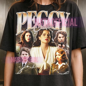 以下が含まれることがあります： ペギー・カーターのグラフィックプリントが施された黒の半袖Tシャツ。上部には大きなフォントで「PEGGY CARTER」の文字があり、その周囲にはキャラクターの5種類の写真画像が配置され、白い稲妻のエフェクトで装飾されています。