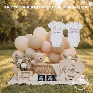 May include: A baby announcement setup with white onesies that read "Prayed for one" and "Blessed with two" hanging above a display. The display includes balloons, a teddy bear, ultrasound photos, and a wooden heart with the name "William" and the word "Twins".