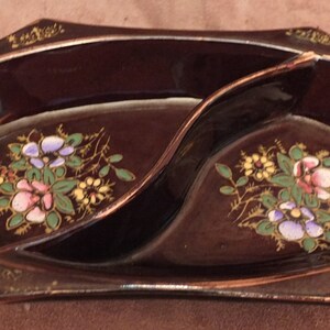 May include: A brown ceramic divided serving dish with gold trim and floral designs in pink, blue, and yellow.