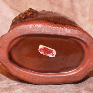 May include: Brown ceramic owl figurine with gold accents. The bottom of the figurine has a label that reads "renn Pittsburgh Made in".