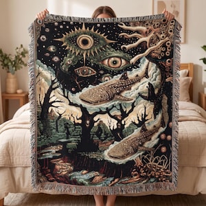 May include: A woven throw blanket featuring a surreal dark scene with two whale sharks swimming through a forest landscape. The sky is filled with multiple large, detailed eyes and starry patterns, while the edges have a decorative fringe border.