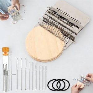 Op de afbeelding: Een houten weefgetouw met een metalen frame, een set naalden en zwarte elastiekjes. Het weefgetouw heeft een ronde houten basis en een metalen bovenkant met meerdere sleuven. De naalden zijn zilverkleurig en variëren in grootte.