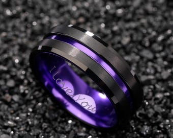 May include: A black ring with a purple interior and a silver stripe. The ring has the words "I Love You" engraved on the inside. The ring is made of metal.