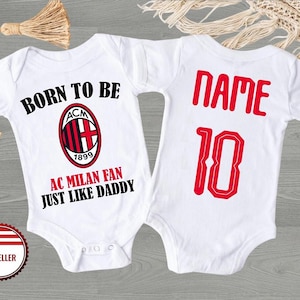 May include: White baby bodysuit featuring the text "BORN TO BE AC MILAN FAN JUST LIKE DADDY" and the AC Milan logo. The back of the bodysuit has the word "NAME" and the number "10" in red. A US seller badge is visible.