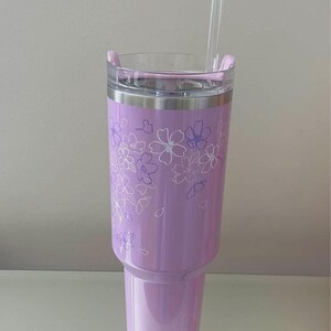 May include: A set of three ceramic mugs with a speckled, matte finish. The mugs are in shades of cream, light brown, and dark brown. Each mug has a simple, minimalist design and a rounded handle.