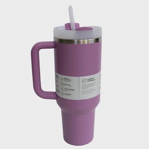 May include: A large, lavender insulated tumbler with a handle and a white lid. The tumbler has a stainless steel rim and a white straw. A label with text is visible on the side.