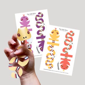 May include: Printable snake party decorations. The Little Party printables. Includes two sheets with snake cutouts in purple, yellow, and orange. The snake cutouts have a repeating pattern of black, white, and yellow stripes. The snake heads are 3D.