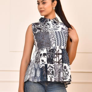 Peut inclure: Haut sans manches en patchwork dans les tons de gris, blanc et bleu marine. Le haut présente un col chemise et un ourlet péplum. Le tissu est orné de motifs floraux, géométriques et animaliers. Le haut est associé à un jean en denim bleu.