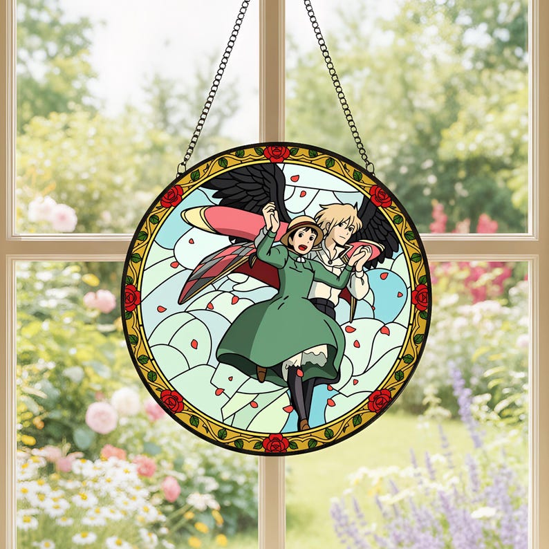 May include: Round stained glass window featuring a couple from the animated film, Howl's Moving Castle. The design includes a green dress, black wings, and red roses around the edge. The window is suspended by a metal chain.