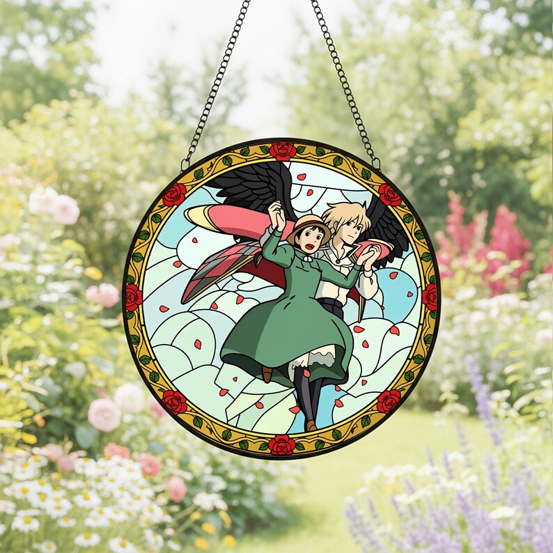 May include: Round stained glass window featuring a cartoon couple with wings, set against a light blue sky with falling petals. The border is gold with red roses. The window hangs from a chain.