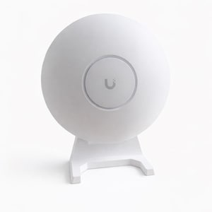 Könnte beinhalten: Ein weißes, kugelförmiges Gerät mit einem kreisförmigen Einsatz mit einem 'U'-Logo. Es ist auf einem weißen, eckigen Ständer montiert. Das Design ist minimalistisch und modern, was auf ein Netzwerk- oder Kommunikationsprodukt hindeutet.