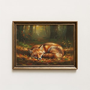 以下が含まれることがあります： 森の中で眠るキツネを描いた額入りの絵画。赤茶色の毛皮を持つキツネが、落ち葉の上に丸まっています。背景には木々と小道があり、暖かく秋らしい色合いです。茶色の木製フレームに入っています。