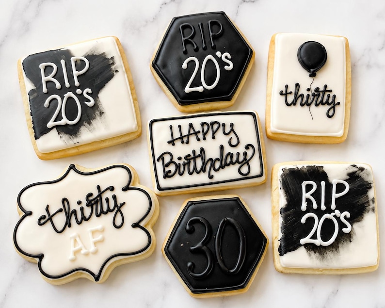 May include: A collection of seven decorated sugar cookies in black and white. Designs include text reading RIP 20's, thirty, Happy Birthday, and 30, along with a black balloon graphic. The cookies are square, hexagonal, and scalloped in shape.