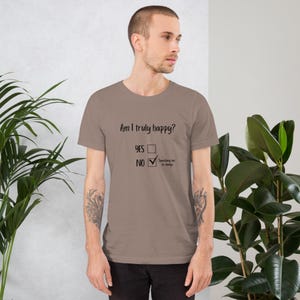 May include: A tan t-shirt with the question "Am I truly happy?" printed in black. The options "YES" and "NO" are listed below the question, with a checkmark next to "NO" and the text "Something has to change".