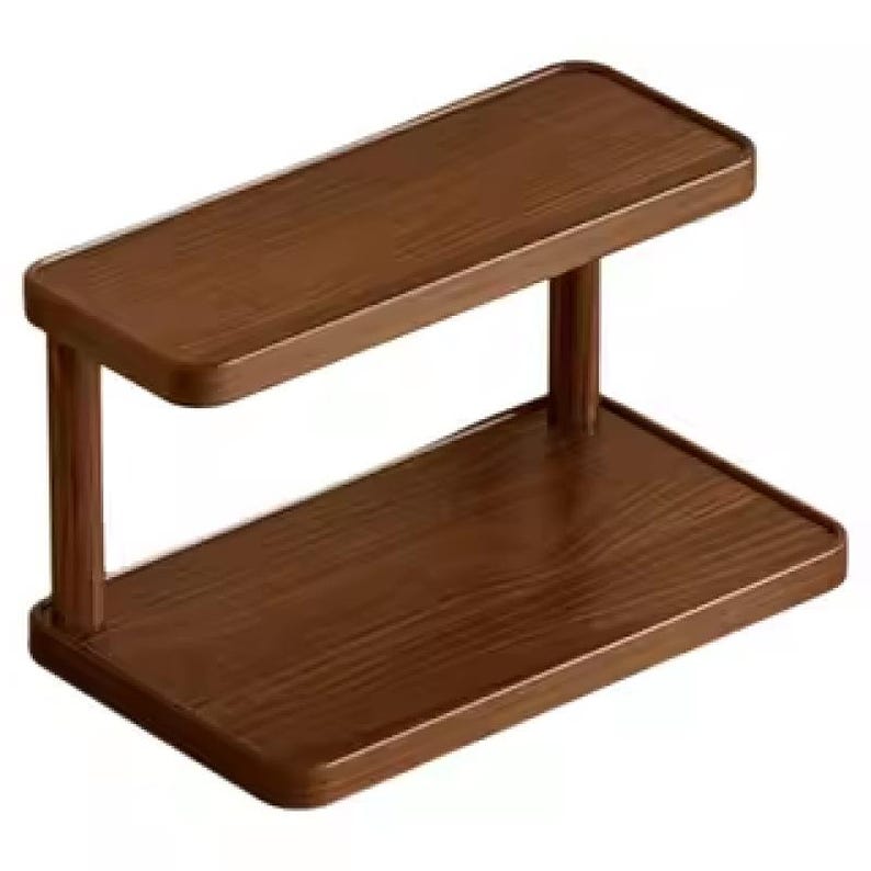 May include: A two-tier rectangular shelf unit constructed from dark brown wood with a visible grain pattern. The unit features a flat base and a matching upper shelf supported by two vertical pillars, creating an open storage structure.