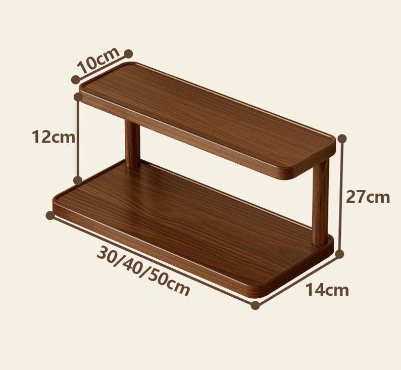 May include: A two-tier rectangular wooden shelf with a dark brown wood grain finish. The shelf features a top tier measuring 10 cm deep, a 12 cm vertical clearance, and a total height of 27 cm. The base width is labeled as 30, 40, or 50 cm, with a 14 cm depth.