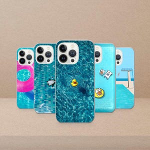 May include: A collection of phone cases with various designs. One case features a pink and blue inflatable ring, another shows a swimming pool with a black and white penguin, and a third has a yellow rubber duck. The other two cases have cartoon graphics.