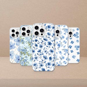 May include: Five smartphone cases arranged in a row, each featuring a unique blue floral pattern on a white background. The designs range from large, sparse watercolor-style blossoms to dense, intricate clusters of small blue flowers and green leaves.