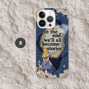 Pode incluir: Capa de telefone transparente com um design inspirado em Alice no Pa&iacute;s das Maravilhas. A capa tem um fundo azul com nuvens brancas e estrelas. A imagem inclui Alice, um coelho e o texto "in the end, we'll all become stories."