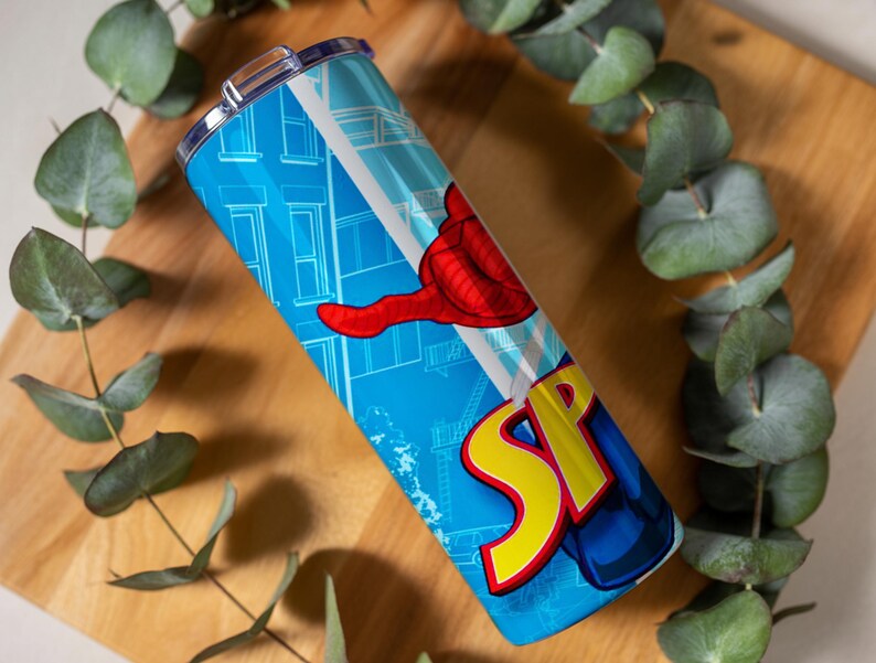 Pu&ograve; includere: Un bicchiere blu con un design a fumetti, con la parola "SP" in giallo e rosso e una mano rossa. Il design include uno sfondo di paesaggio urbano. Il bicchiere &egrave; in acciaio inossidabile e ha un coperchio argentato.