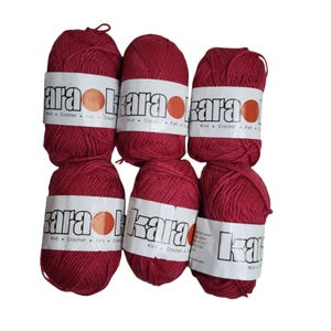 May include: Six balls of red yarn with the word "kara" printed on the label. The yarn is for knitting and crocheting.