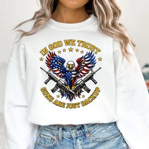 In God We Trust guns are just backup patriotic eagle design with American flag wings and crossed rifles on black background