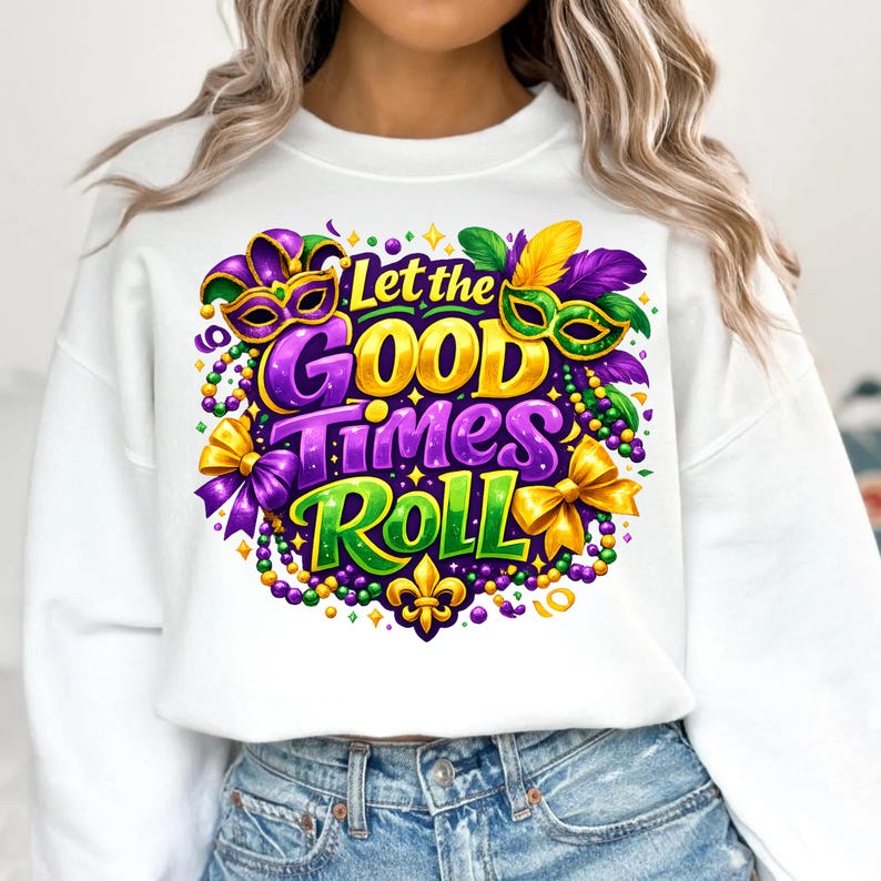 Op de afbeelding: Witte sweatshirt met een kleurrijke afbeelding met de tekst "Let the Good Times Roll". Het ontwerp bevat Mardi Gras-maskers, kralen, strikken en een fleur-de-lis in paars, groen en goud.