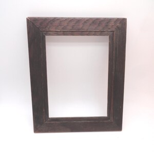 May include: A rectangular picture frame constructed from dark brown wood with a visible grain pattern. The frame features mitered corners and a flat, wide border design, providing a simple and functional structure for displaying artwork or photographs.