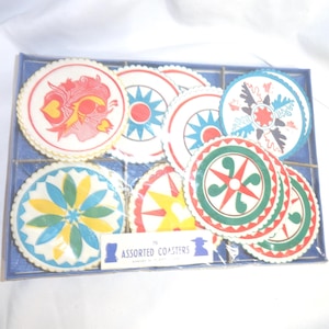 May include: A set of 10 assorted paper coasters in a clear plastic package. The coasters are round and feature various colorful geometric designs. The package has a blue background and the text "Assorted Coasters" printed on it.