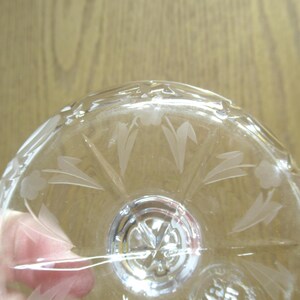 Op de afbeelding: Transparante glazen kom met ge&euml;tste bloemen- en bladerenpatronen. De kom heeft een gedetailleerd patroon rond de rand en een centraal ontwerp. Het transparante glas laat licht door, waardoor de ge&euml;tste details worden benadrukt.
