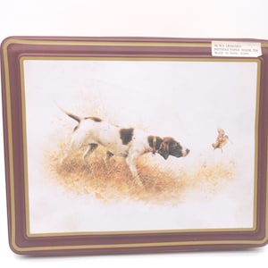 May include: Rectangular serving tray with a brown border and a gold inner trim. The tray features a hunting scene with a dog and a bird. The dog is white with brown spots and is in pursuit of the bird. The tray is labeled "50 PCS DESIGNED NOTEPAD PAPER INSIDE TIN MADE IN HONG KONG."