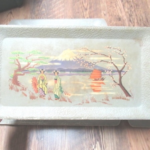 May include: Rectangular serving tray with a textured, light green surface. The tray features a Japanese landscape scene with Mount Fuji, cherry blossoms, and figures in traditional attire. A red boat sails on the water.