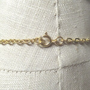 May include: A gold chain necklace with a lobster clasp closure.